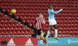 . Duncan Watmore of Sunderland contests a header with Nathaniel Ogbeta of Manchester City...