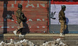 Indian paramilitary soldiers walk past closed shutters in Srinagar,Kashmir on the hanging...