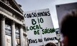 Activist holding an umbrella painted with slogans. lMarches and rallies against seed giant...
