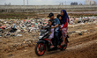 A family riding on a motorcycle among garbage at Slum Area in Jakarta, Indonesia on Februa...