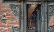 A man in uniform cleans shoes at the square near the Dattatreya Temple, Bhaktapur, Nepal,...