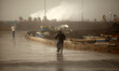Palestinians walk on the seafront as a large wave collides with the break wall at the Gaza...