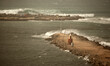 A Palestinian man takes photos of large waves colliding with the break wall at the Gaza se...
