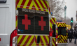 Ambulances and police officers gather in front of the offices of the French satirical news...