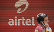 A man walks past a shop painted with an advertisement of India’s telecom giant Bharti Airt...