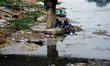 A Bangladesh woman collects plastic from the polluted Turag River in Dhaka, Bangladesh, on...