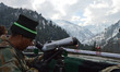 Photo taken on 14 Jan 2014: An Indian Army soldier watches towards Pakistani post through...
