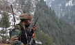 Photo taken on 14 Jan 2014: An Indian Army soldier talks on a walkie-talkie while keeping...