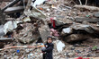 Palestinian children carrying water as they walked in front of their destroyed homes in Sh...