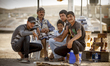 A young group of syrian refugees in front of their cigarette shop inside the Quru Gusik Re...