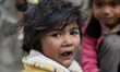 Portrait of a homeless Kid while eating food outside a Metro station in New Delhi, India,...