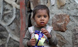Portrait of a homeless Kid while eating food outside a Metro station in New Delhi, India,...