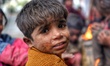 Portrait of a homeless Kid while eating food outside a Metro station in New Delhi, India,...
