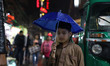 A boy holds an Umbrella during light rainfall in the Old  Quarters of Delhi, India, on 3 M...