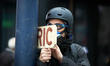 A protester holds a wooden placard reading 'RIC' (which stands for Citizens Initiated Refe...