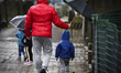 A man holds an umbrella to protect a child from the rain in Bydgoszcz, Poland on March 9,...