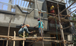 Workers complete cement work on a newly built home in the city of Thiruvananthapuram (Triv...