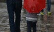 A Kid walks along with his father as it rains in Srinagar,Kashmir on March 13, 2019. 