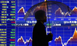 A man walks past a stock quotation board outside a brokerage in Tokyo January 18, 2015. 