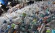 Indian men short out recyclable plastic bottles made from PET (polyethylene terephthalate)...