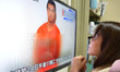 A woman watches a news program, about an Islamic State video purporting to show Kenji Goto...