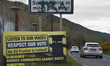 Cars pass a poster by the anti-brexit campaign group 'Border communities against Brexit' o...