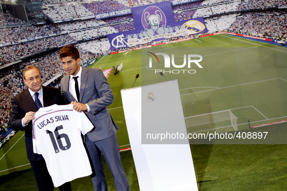 Brazilian football player Lucas Silva poses with his new shirt next to Real Madrid president Florentino Perez during his presentation as new...