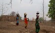 Village living women holds drinking water in pots as they returns back home after collecti...