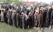 Voters wait to cast their votes outside a polling station in north Kashmir's Shadipora are...