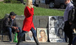 People walk next to paintings of a street artist in a sunny day on the Independence Square...