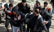 Palestinian demonstrators throw stones at an Israeli bunker as another waves a national fl...