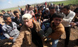 Palestinians carry a man wounded by a bullet to his leg during clashes between demonstrato...