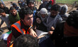 Palestinians carry a man wounded by a bullet to his leg during clashes between demonstrato...