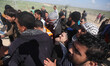 Palestinians carry a man wounded by a bullet to his leg during clashes between demonstrato...