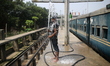 A Bangladeshi railway worker baths on a hot summer day as heat near 40 degrees Celsius in...