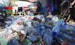 A scavenger cleans plastic bottles for sale at a garbage dump in Bogor, West Java, Indones...
