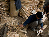 HALMULLAH, INDIAN ADMINISTERED KASHMIR, INDIA - FEBRUARY 11: Workers fix handles to unfinished cricket bats in a bat factory on February 11,...