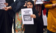 A Kashmiri young girl holds placard during a  protest against the rape of a three year old...