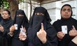 Indian Muslim women voters showing inked finger after casting their vote at a polling stat...