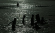 Palestinian children play in the Mediterranean sea on the beach in Gaza City during a heat...