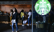 Customers walk past in a Starbucks Corp. coffee shop at Shopping Mall, in Bangkok, Thailan...