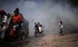 Bangladeshi people seen walking as toxic garbage are burning besides a road near Buriganga...