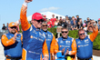 Scott Dixon (9) of New Zealand and Chip Ganassi Racing celebrates with his team behind him...