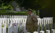 A tourist wearing a British solder uniform walks between tombstones at the Bayeux War Ceme...