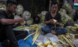 Sellers offer a woven diamond shaped palm leaf pouch “ketupat” to be cooked as rice pouch...