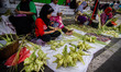 Vendors selling ketupat (rice cake boiled in a packet of young coconut leaves) prepare the...