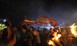 Nepalese devotees carry a traditional straw torch to welcome idol Rato Machindranath in Bu...
