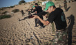 A Palestinian boy shoots via AK47 on fake targets during a military training by Members of...