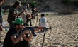 Young Palestinian boys shoots via AK47 on fake targets during a military training by Membe...