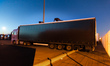 Migrants on top of a truck try to access the container by cutting a hole on the lining. Ca...